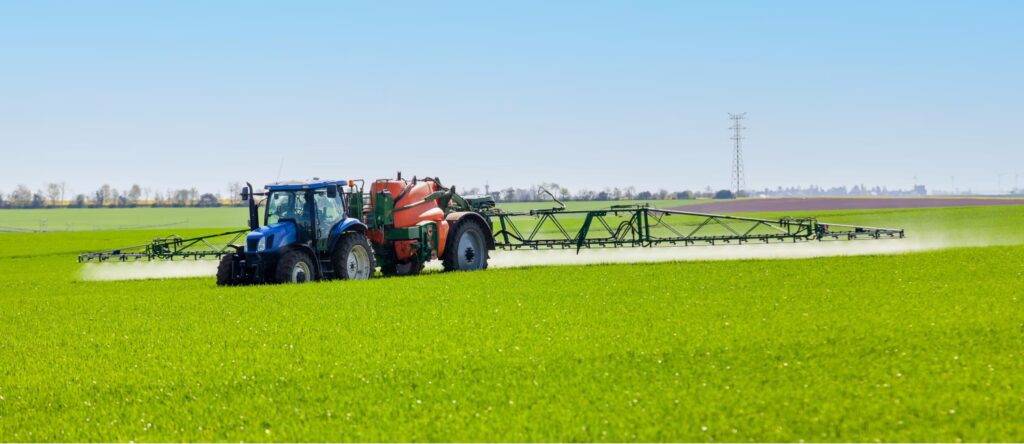 tracteur agricole et pulvérisateur lors d'un traitement à base de produit phytosanitaire sur une culture