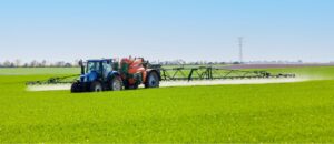 tracteur agricole et pulvérisateur lors d'un traitement à base de produit phytosanitaire sur une culture